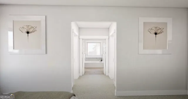 a view of a hallway with wooden floor and a bathroom