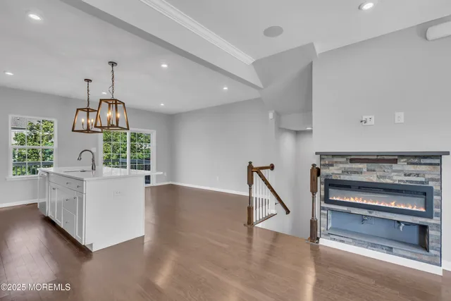 a kitchen with refrigerator and wooden floor