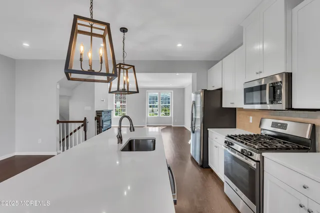 a kitchen with stainless steel appliances granite countertop a sink a stove and a refrigerator