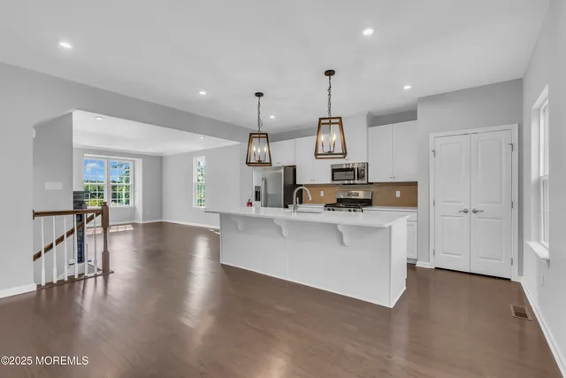 a view of a hallway with wooden floor and furniture