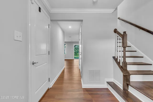 a view of a hallway with wooden floor and entryway
