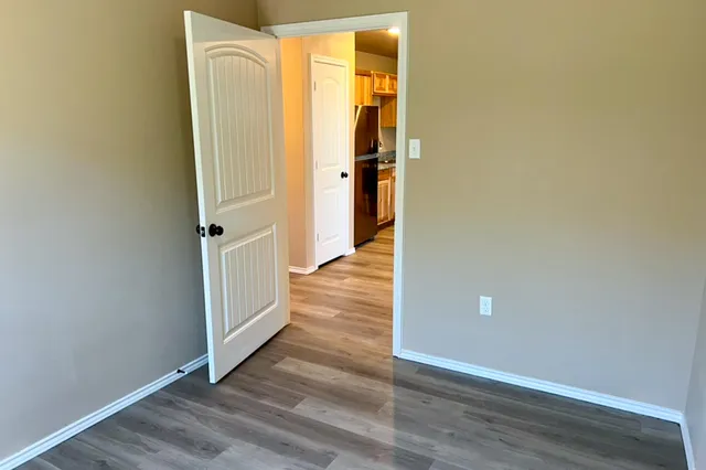 a view of a hallway with wooden floor