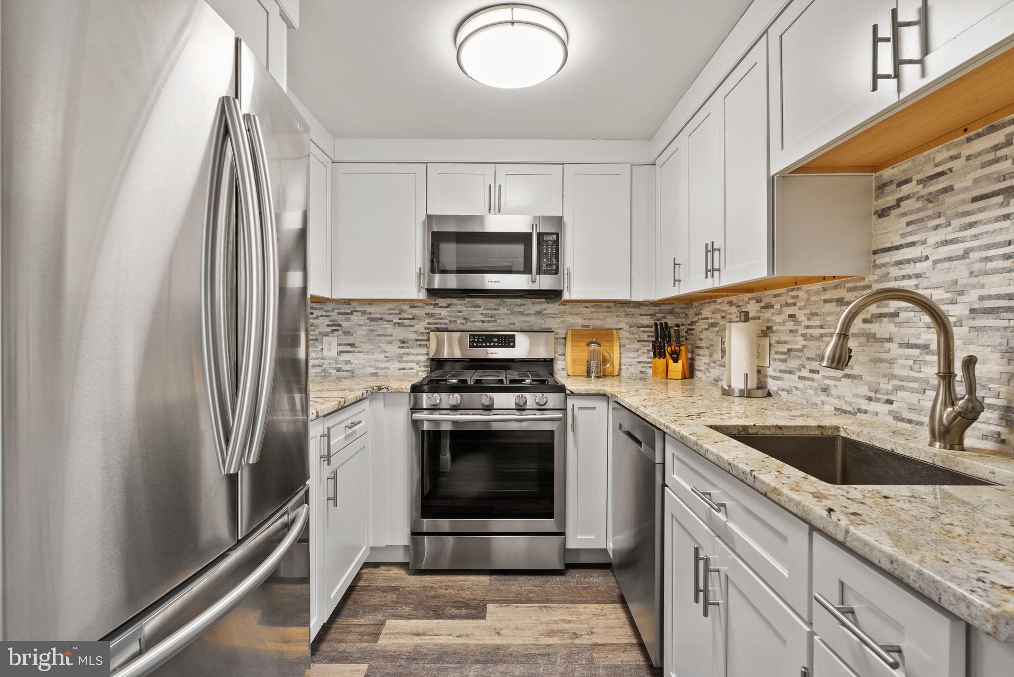 649 C Street Southeast, Unit 304 Washington, DC 20003 - Photo 12 of 37 a kitchen with stainless steel appliances granite countertop a sink stove and refrigerator