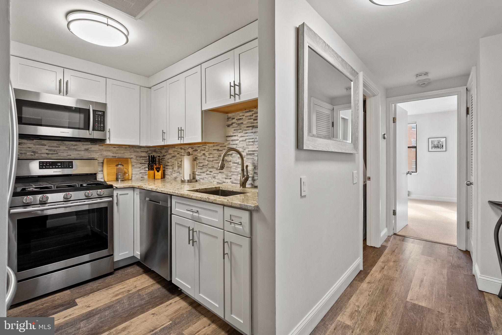 649 C Street Southeast, Unit 304 Washington, DC 20003 - Photo 14 of 37 a kitchen with stainless steel appliances granite countertop a stove and a refrigerator