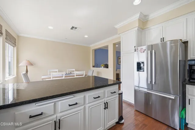 a kitchen with stainless steel appliances a refrigerator sink and white cabinets