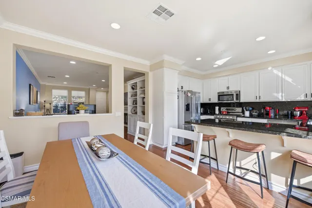 a kitchen with stainless steel appliances kitchen island granite countertop a refrigerator and microwave