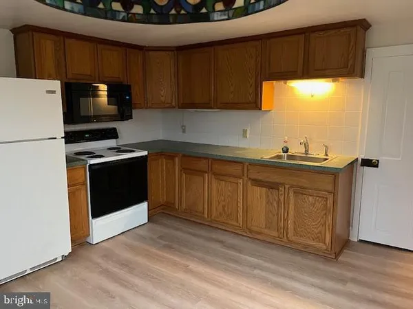 a kitchen with stainless steel appliances a stove a sink and a microwave
