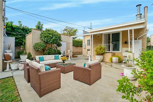 front view of a house with potted plants and a bench