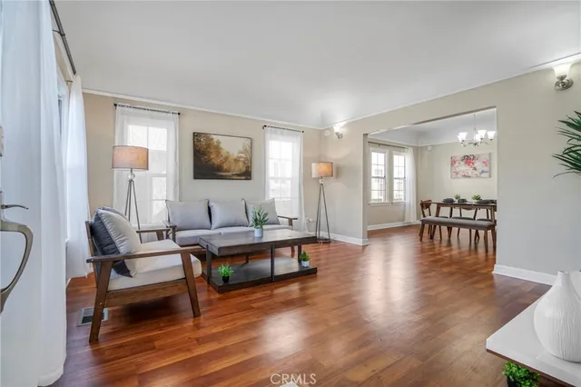 a living room with furniture flat screen tv and wooden floor