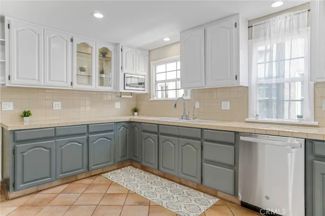 a kitchen with white cabinets and white appliances