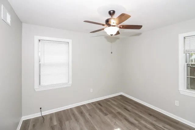 an empty room with a window and a fan