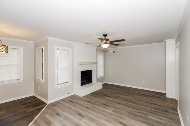 a view of a livingroom with wooden floor and a fireplace