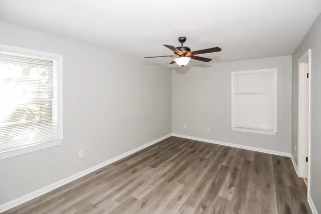 a view of a room with wooden floor and a ceiling fan