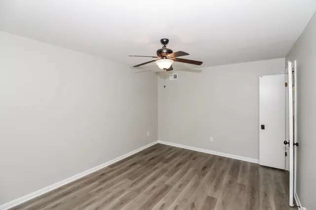 a view of a small space with wooden floor and a chandelier fan