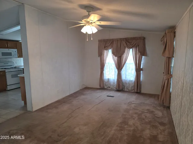 an empty room with a windows and a chandelier