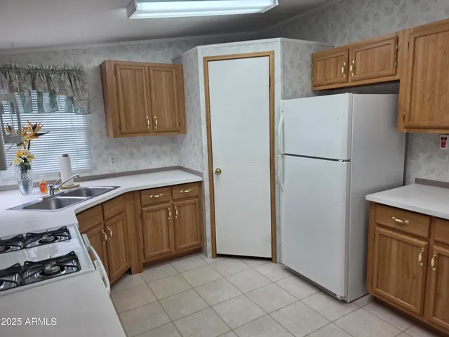 a kitchen with sink a refrigerator and a stove top oven