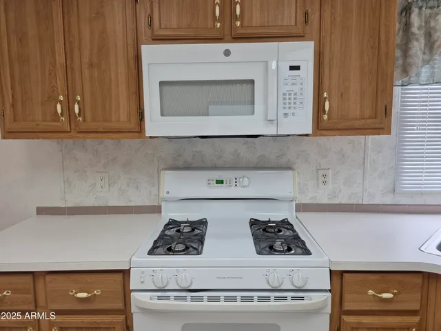 a stove top oven sitting inside of a kitchen