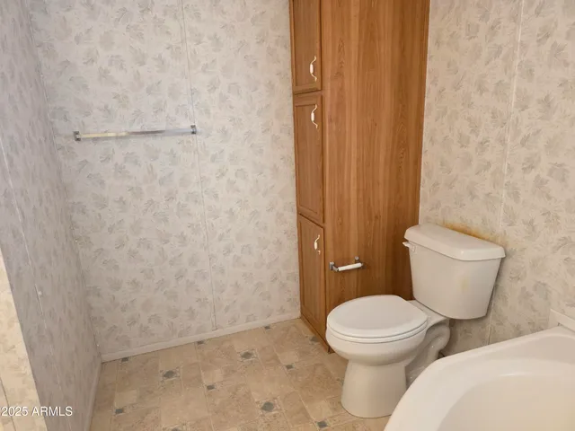 a white toilet sitting next to a shower curtain
