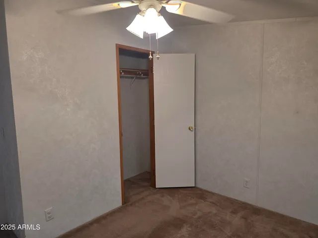 an empty room with a chandelier fan