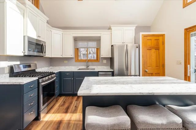 a kitchen with granite countertop a sink stove and refrigerator