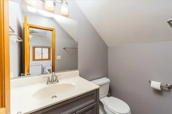 a bathroom with a sink mirror vanity and toilet