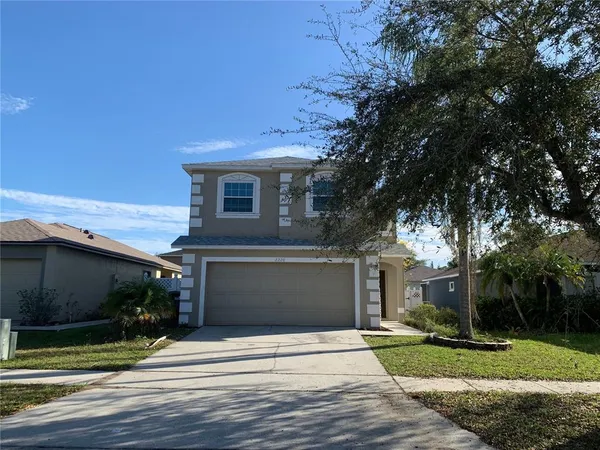a front view of a house with a yard and garage