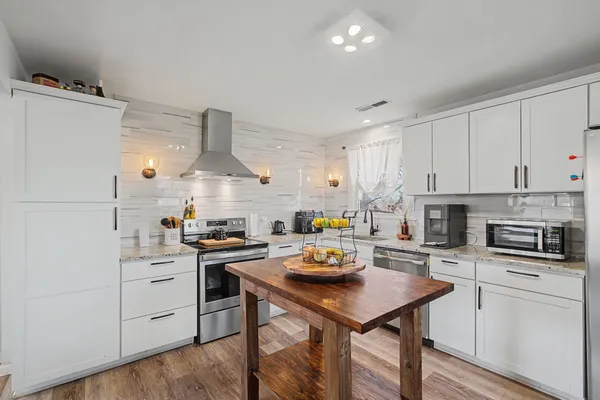 a kitchen with a sink a stove and chairs