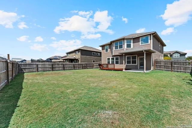 a view of a house with backyard and deck