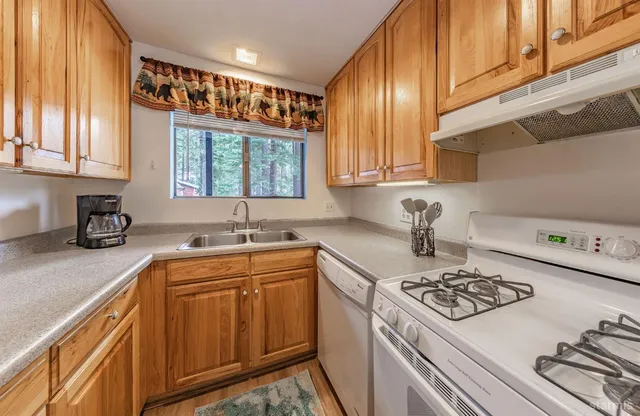 a kitchen with a sink a stove and cabinets