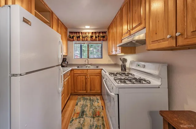 a kitchen with stainless steel appliances granite countertop a stove a refrigerator and a cabinets