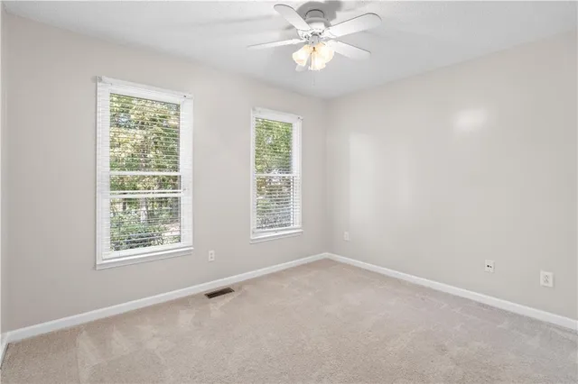an empty room with a window and a fan