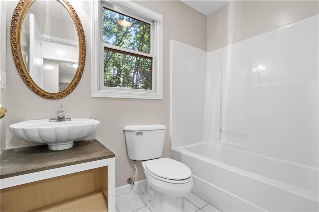 137 Hunters Trail Calhoun, GA 30701 - Photo 23 of 33 a bathroom with a toilet a sink and a mirror