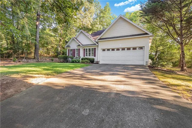 a view of a house with a yard and large trees