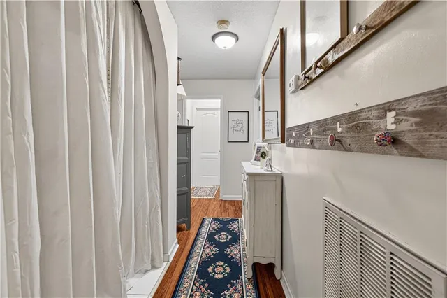 a walk in closet with wooden floor washer and dryer