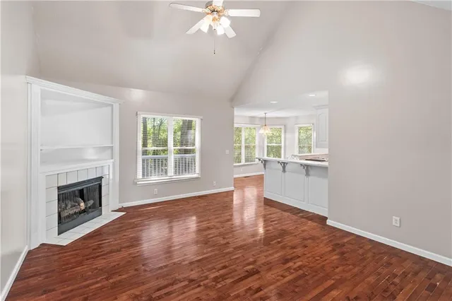 a view of empty room with wooden floor and fireplace
