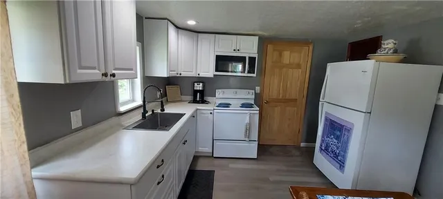 a kitchen with white cabinets and stainless steel appliances