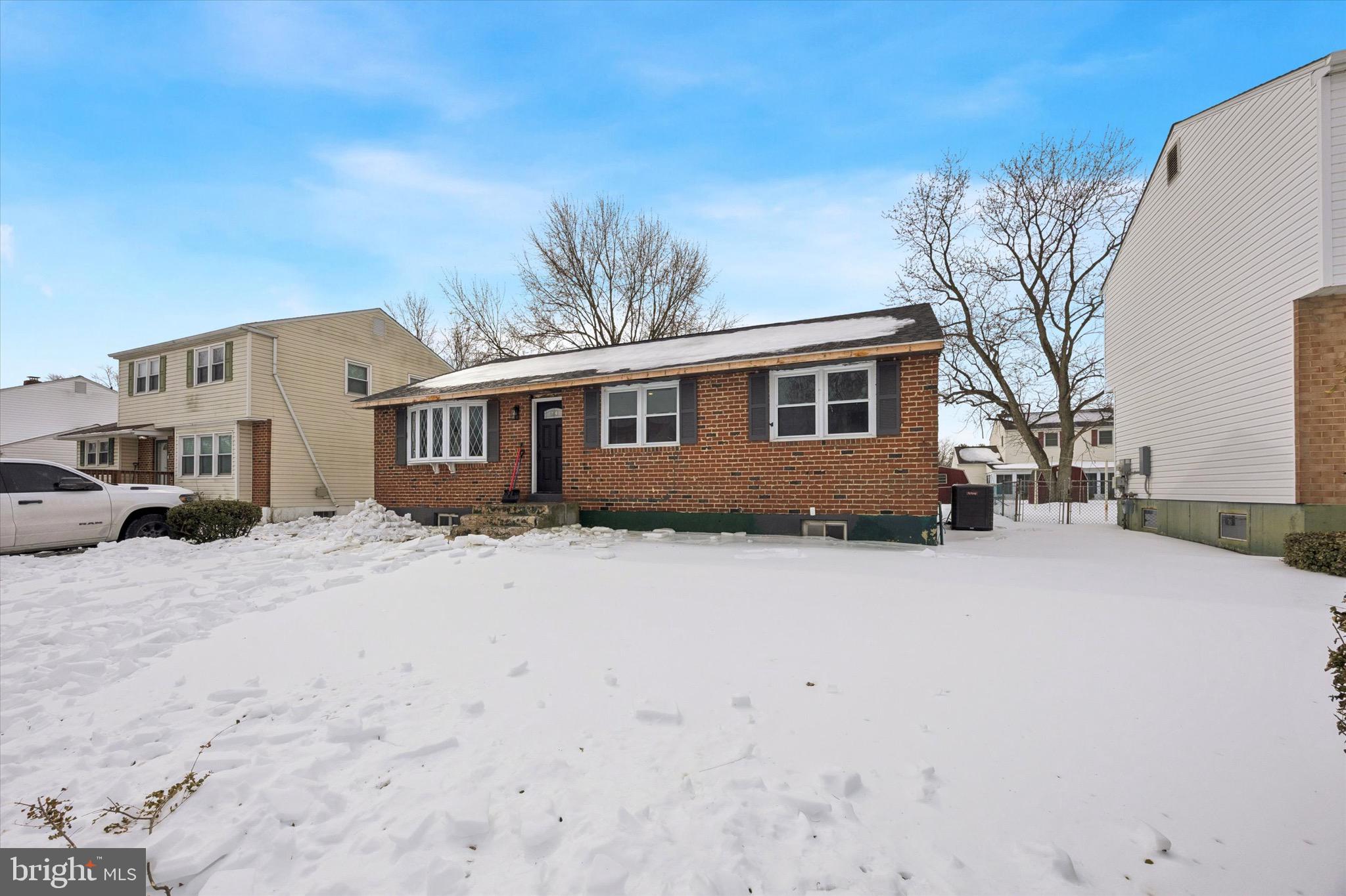 a front view of a house with a yard covered in snow