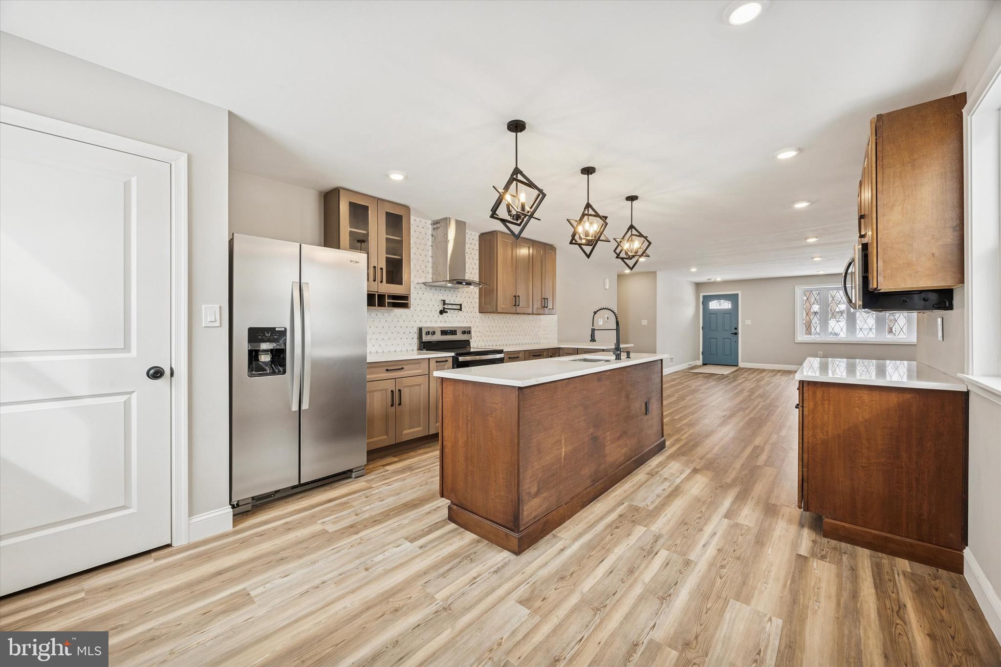 19 Rivanna Road New Castle, DE 19720 - Photo 6 of 26 a kitchen with stainless steel appliances kitchen island granite countertop a refrigerator a oven a sink and a wooden floors