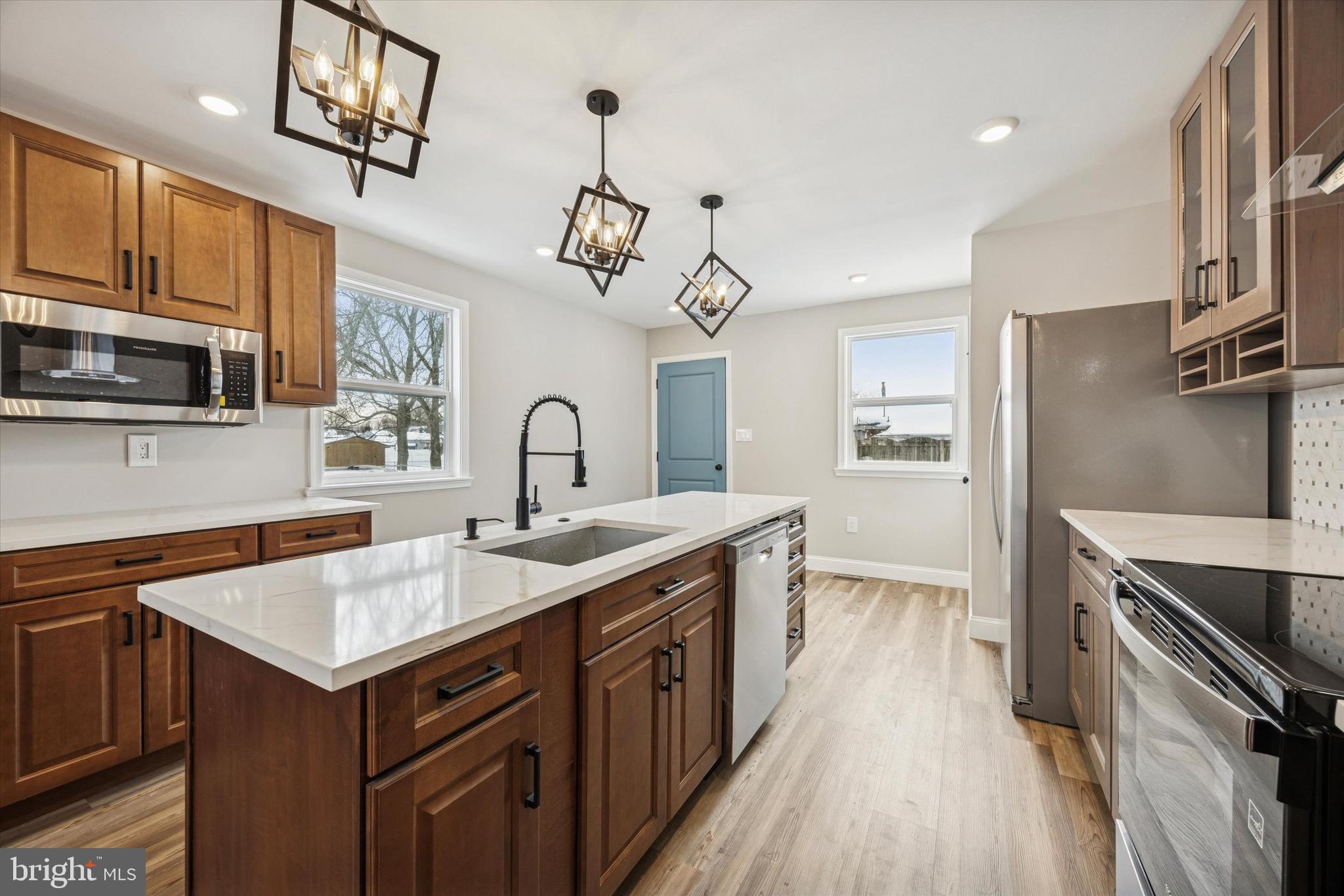 19 Rivanna Road New Castle, DE 19720 - Photo 7 of 26 a kitchen with a sink dishwasher a stove and a refrigerator with wooden floor