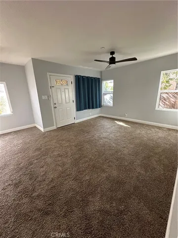an empty room with an entryway and windows