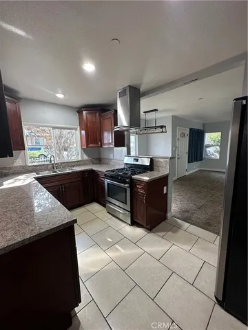 a kitchen with stainless steel appliances granite countertop a sink and a stove