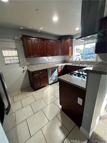 a kitchen with stainless steel appliances granite countertop a stove a sink and a microwave
