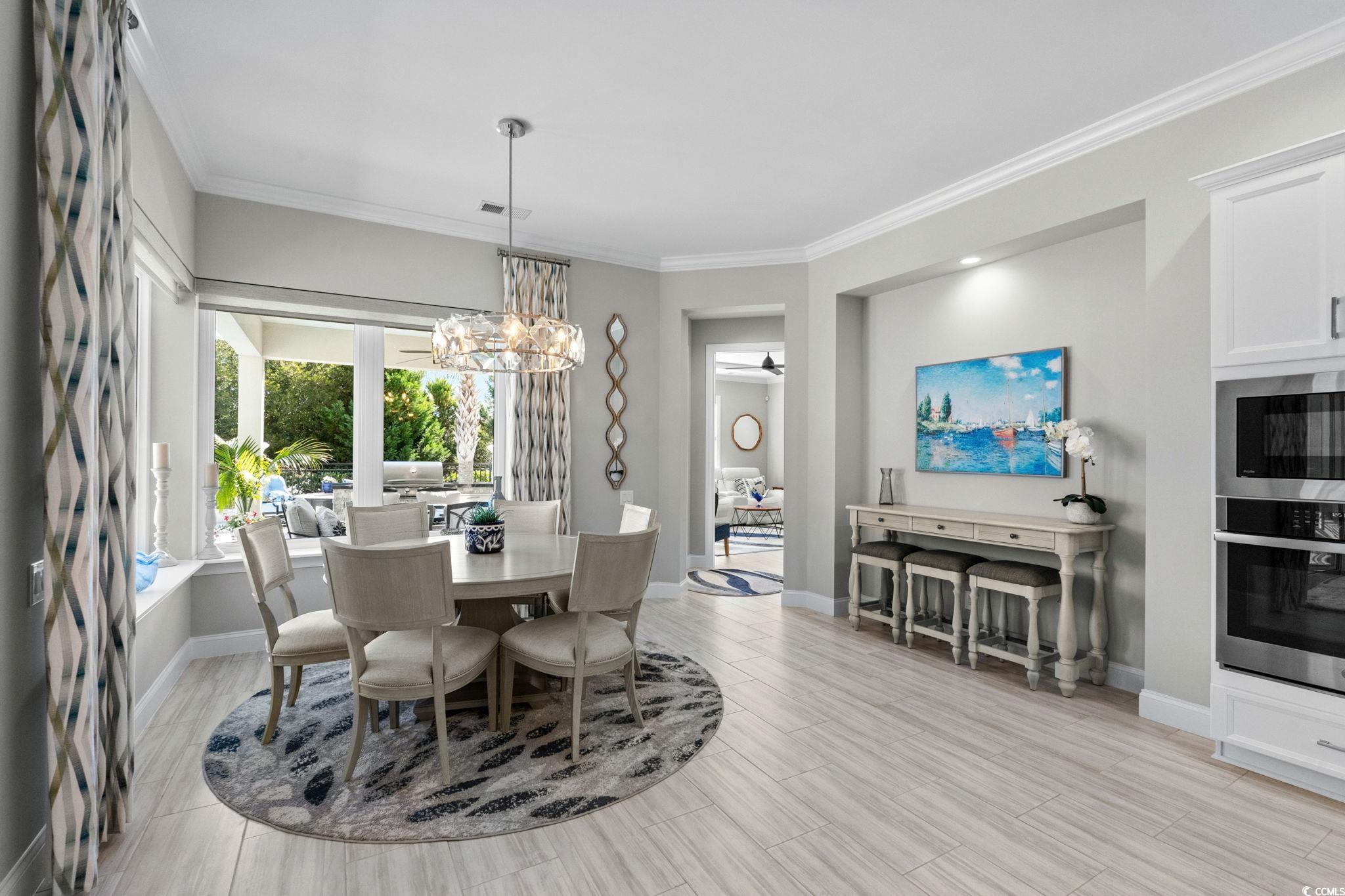2225 Macerata Loop Myrtle Beach, SC 29579 - Photo 15 of 40 Dining room featuring crown molding, a chandelier, and wood tiled floors