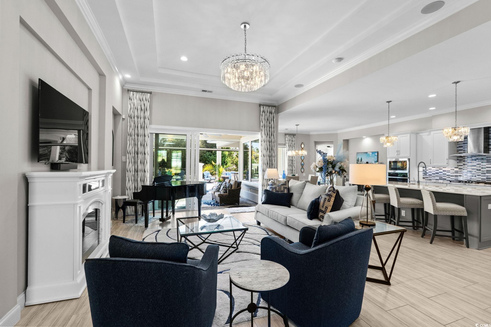 2225 Macerata Loop Myrtle Beach, SC 29579 - Photo 17 of 40 Living room with a chandelier, crown molding, recessed lighting, light wood-style floors, and a raised ceiling