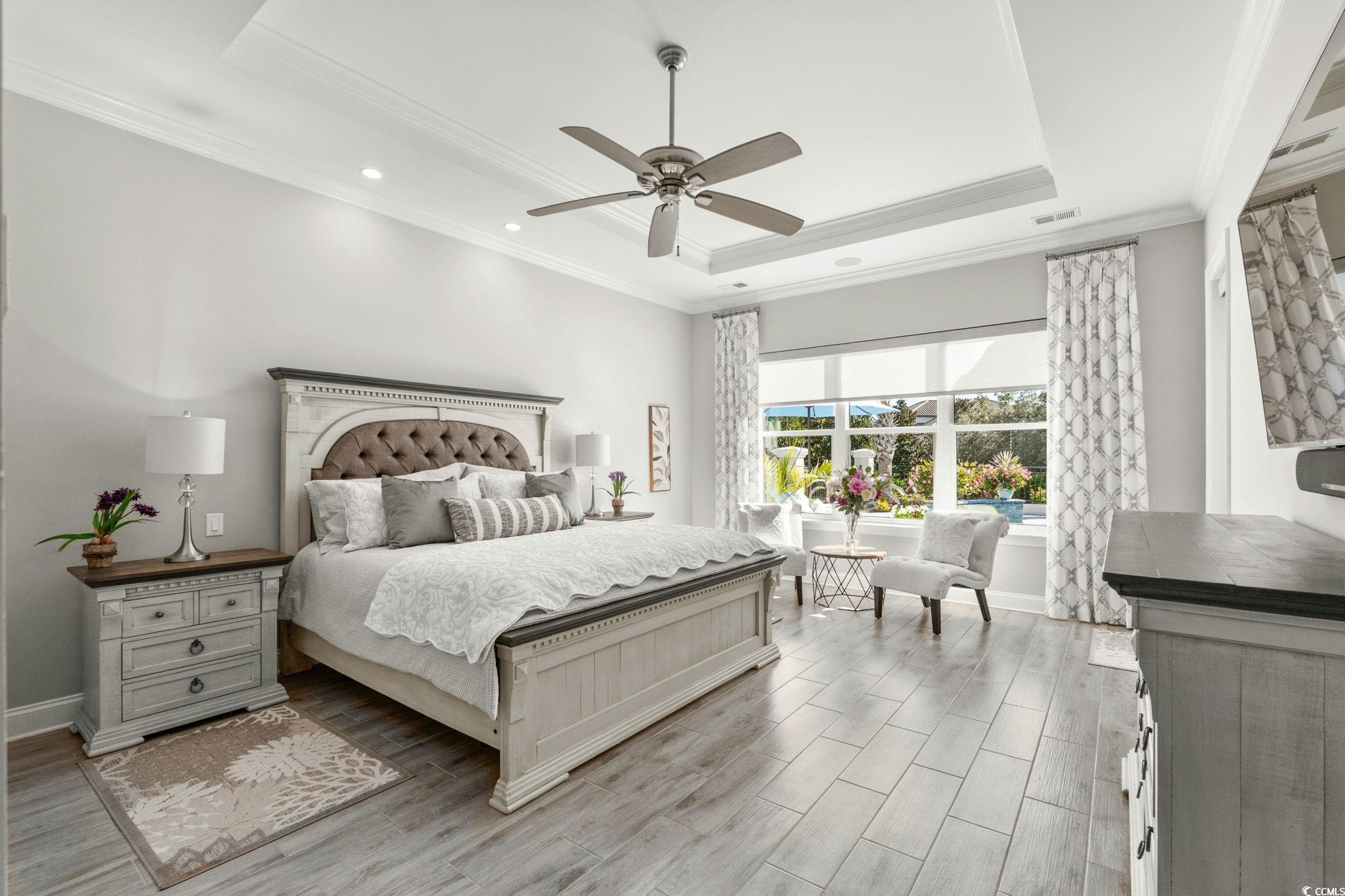 2225 Macerata Loop Myrtle Beach, SC 29579 - Photo 18 of 40 Bedroom featuring ornamental molding, wood finish floors, a tray ceiling, and ceiling fan