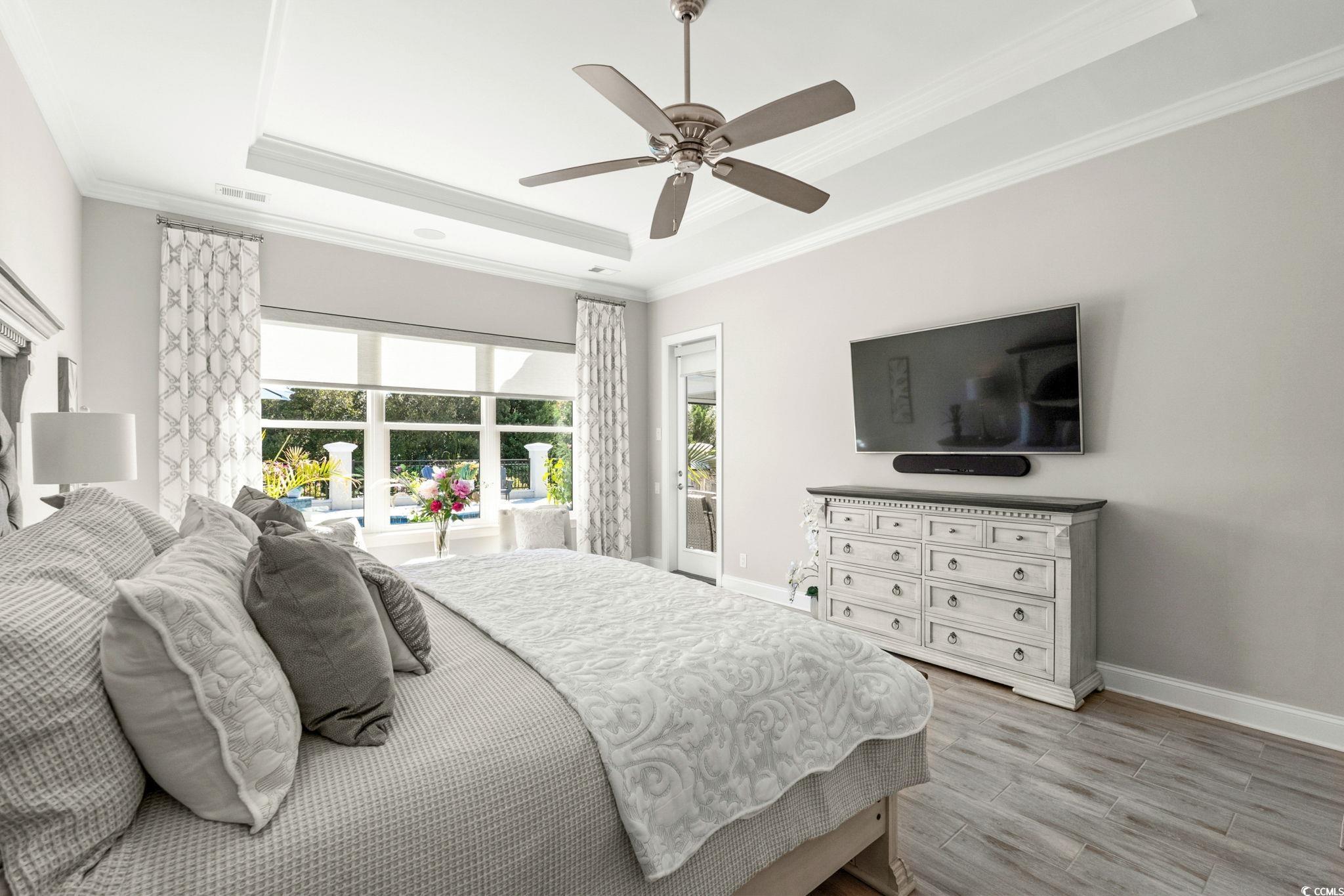 2225 Macerata Loop Myrtle Beach, SC 29579 - Photo 19 of 40 Bedroom featuring access to outside, ornamental molding, light wood-style flooring, a raised ceiling, and a ceiling fan