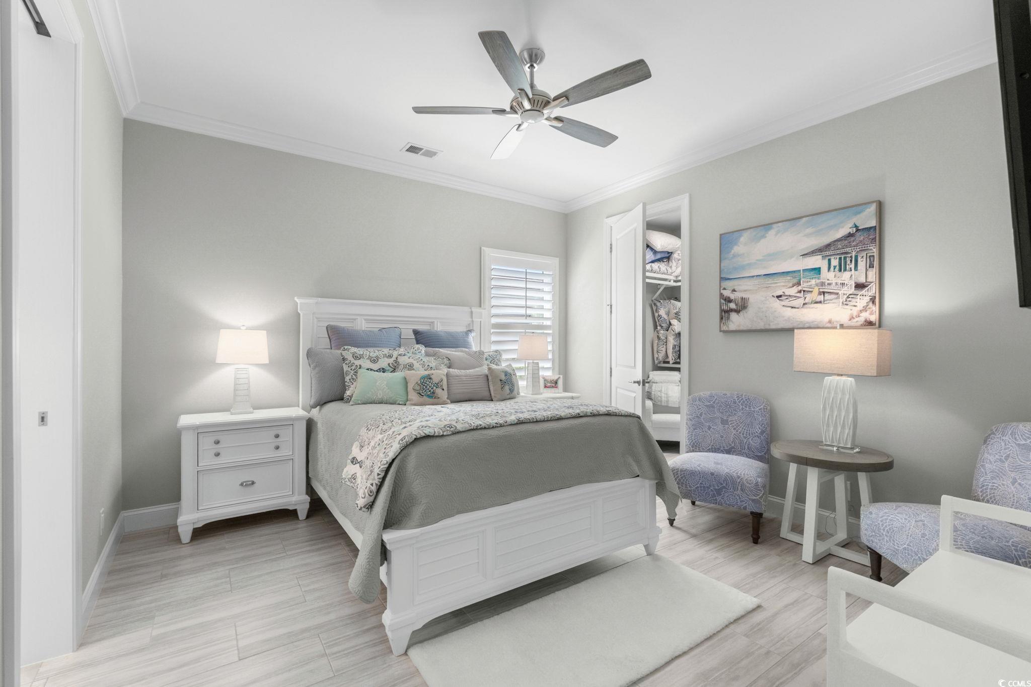 2225 Macerata Loop Myrtle Beach, SC 29579 - Photo 23 of 40 Bedroom featuring ornamental molding, light wood-style flooring, a ceiling fan, and a spacious closet