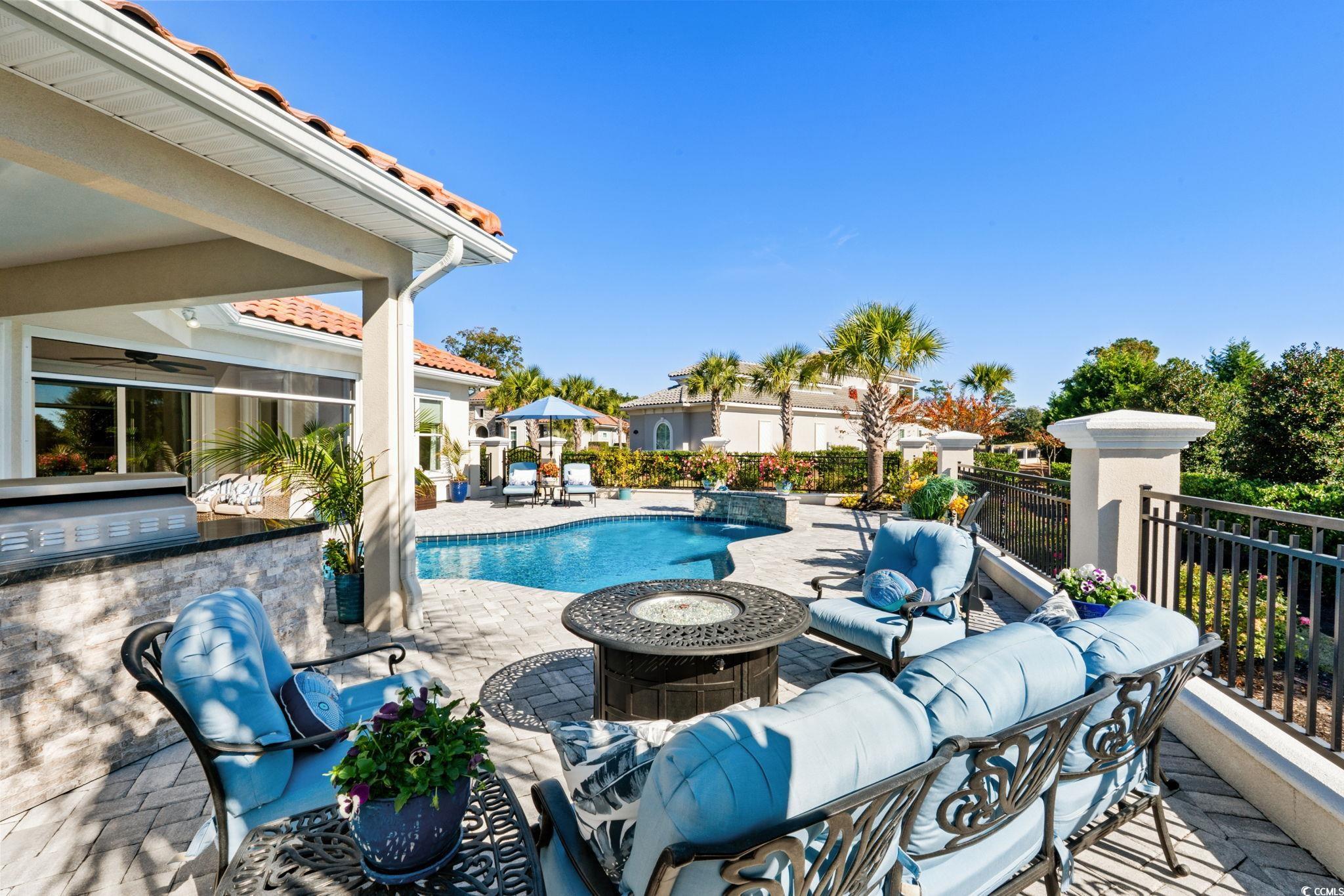 2225 Macerata Loop Myrtle Beach, SC 29579 - Photo 31 of 40 View of pool with a patio, an outdoor kitchen, and an outdoor living space with a fire pit