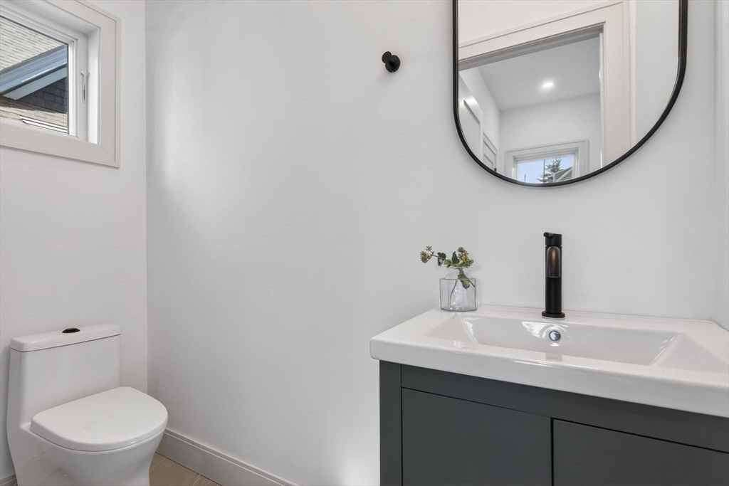 202 Powder House Boulevard, Unit 1 Somerville, MA 02144 - Photo 17 of 26 a bathroom with a sink and a mirror