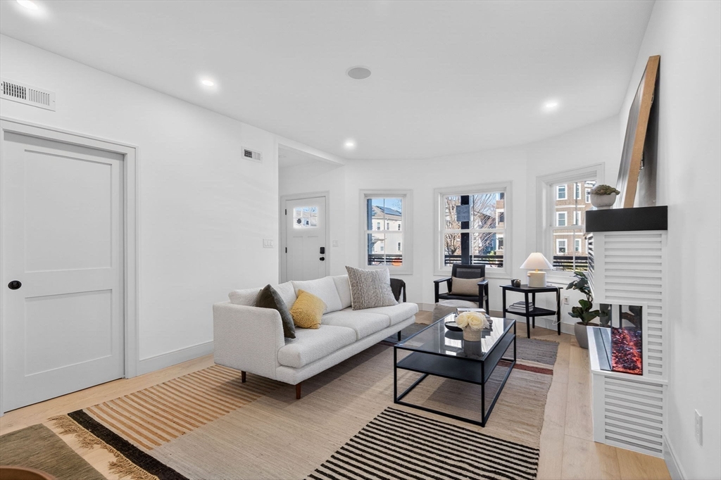 202 Powder House Boulevard, Unit 1 Somerville, MA 02144 - Photo 2 of 26 a living room with furniture a rug and a wooden floor